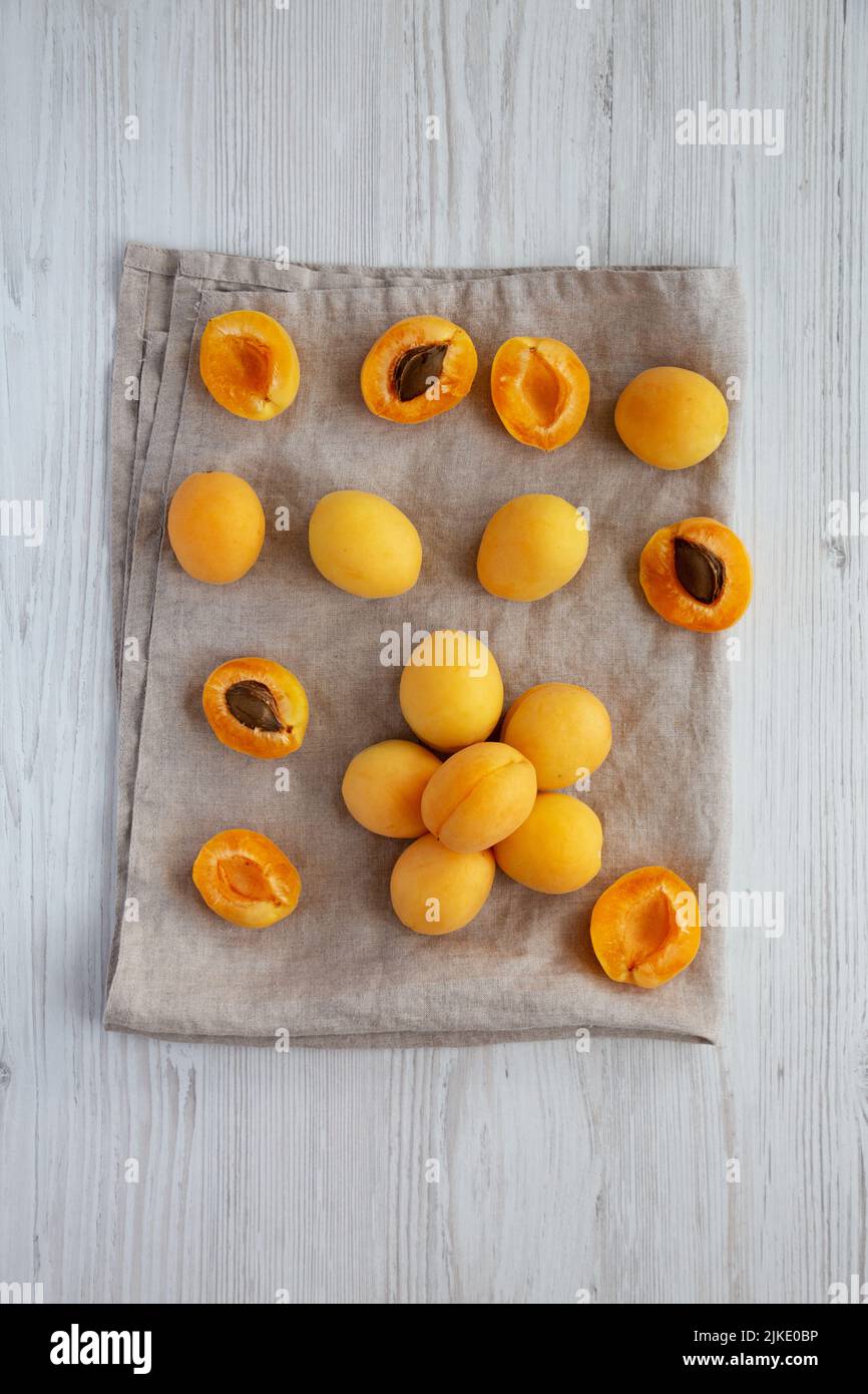 Raw White Apricot Angelcots on a white wooden background, top view. Flat lay, overhead, from above. Stock Photo