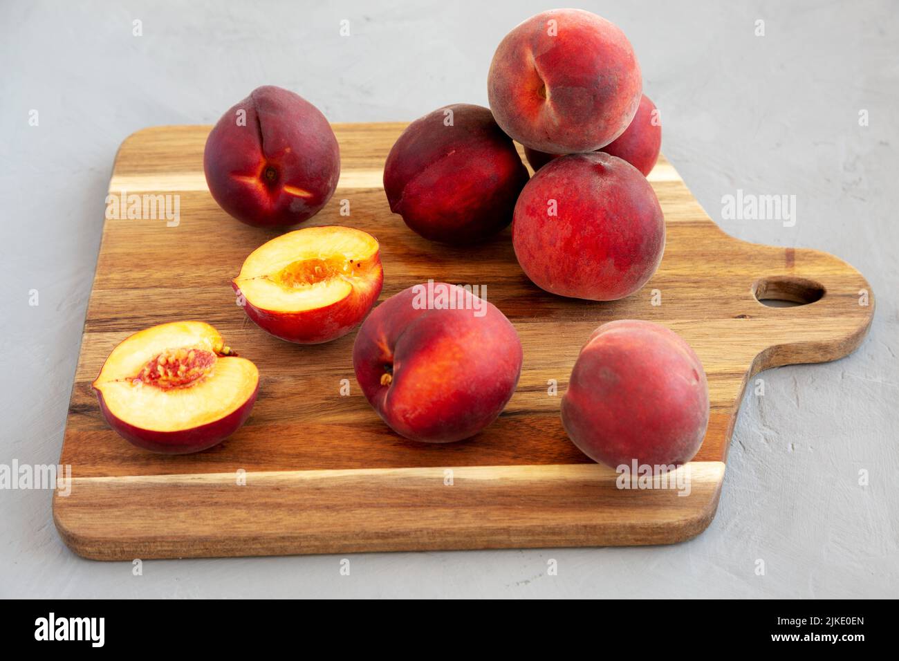 Raw Organic Yellow Peaches on a wooden board, side view. Stock Photo