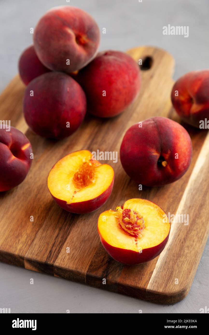 Raw Organic Yellow Peaches on a wooden board, low angle view. Stock Photo