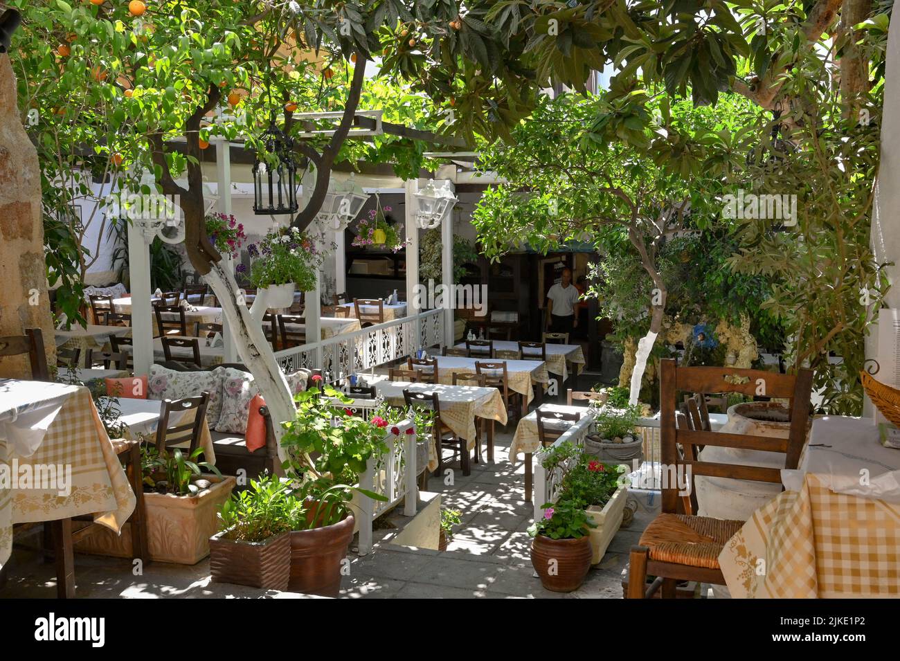 Rhodes, Greece - May 2022: Outdoor seating area in the garden of a traditional Greek Taverna in Rhodes old town Stock Photo