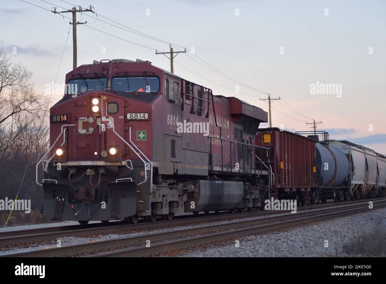 Bartlett, Illinois, USA. A Canadian Pacific Railway looomotive powers a freight train through the northwest suburbs of Chicago just before nightfall. Stock Photo