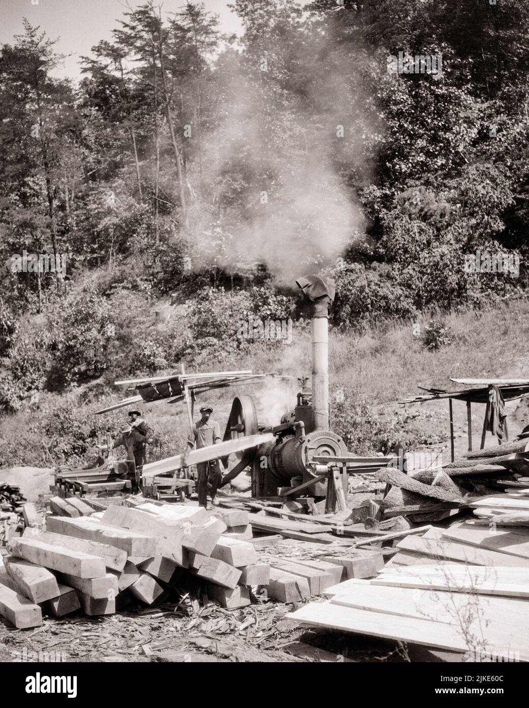 1930s 1940s TWO AFRICAN AMERICAN MEN SAWYERS MANUFACTURING LUMBER ON STEAM ENGINE DRIVEN SAWMILL RURAL VIRGINIA USA - i351 HAR001 HARS B&W NORTH AMERICA NORTH AMERICAN SKILL OCCUPATION SKILLS AFRICAN-AMERICANS AFRICAN-AMERICAN CAREERS TIMBER BLACK ETHNICITY LABOR ON EMPLOYMENT MANUFACTURING OCCUPATIONS CIRCULAR DRIVEN INFRASTRUCTURE EMPLOYEE LUMBER POWERED SAWING SAWMILL VA BLACK AND WHITE HAR001 LABORING OLD FASHIONED AFRICAN AMERICANS Stock Photo