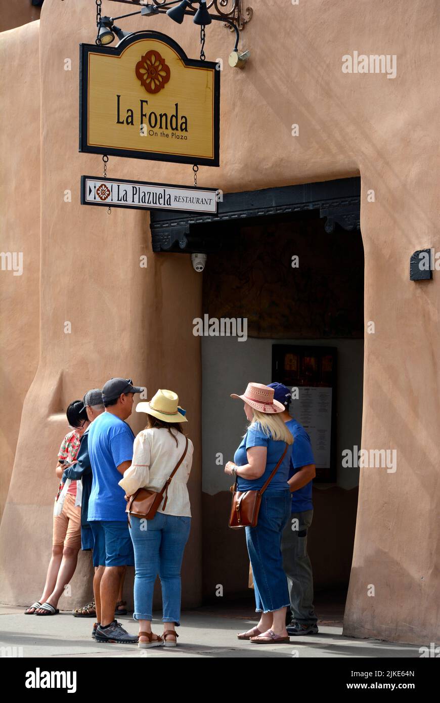 Tourists pause at the entrance to the historic La Fonda Hotel in Santa ...