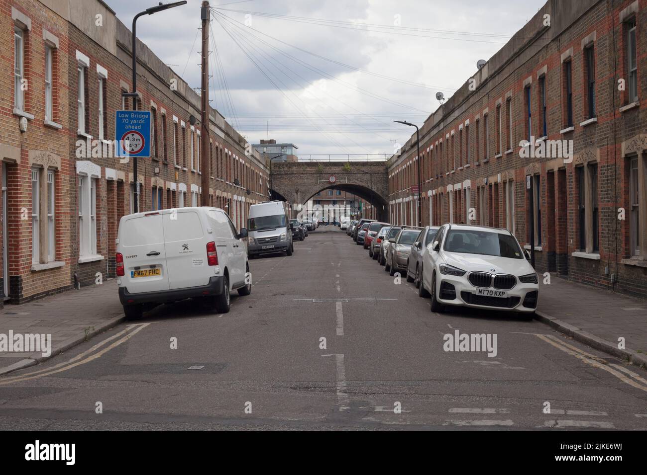 Street of terraced houses with railway bridge Beck Road Hackney London E8 Stock Photo