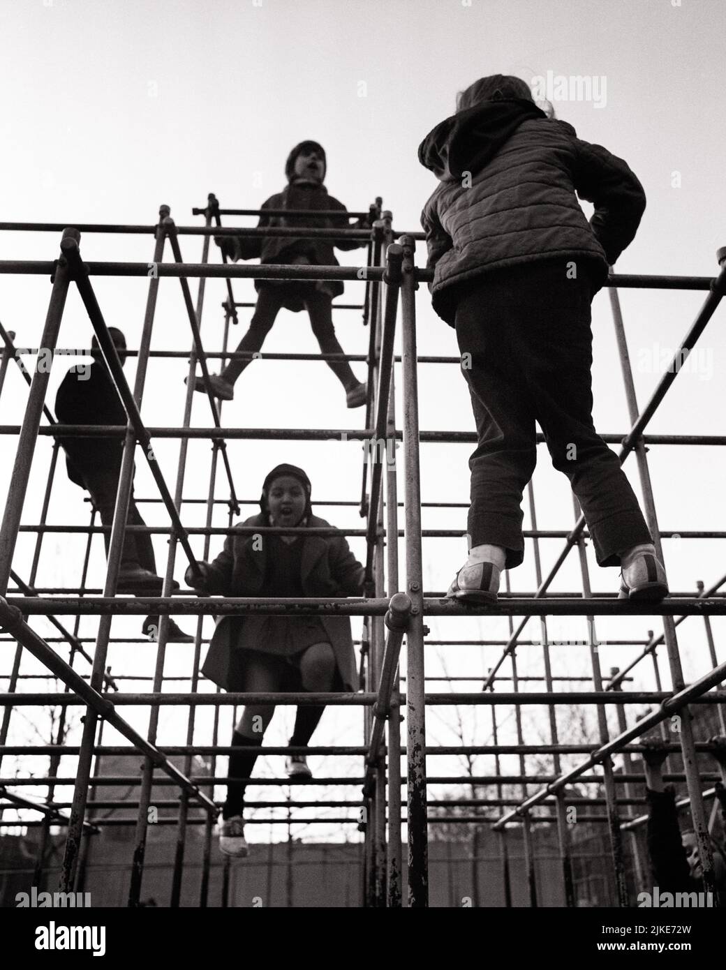 1970s SILHOUETTED KIDS 2 BOYS AND 2 GIRLS PLAYING CLIMBING ON PLAYGROUND JUNGLE GYM - j13231 HAR001 HARS FEMALES COATS COPY SPACE FRIENDSHIP FULL-LENGTH PHYSICAL FITNESS PERSONS MALES SILHOUETTES B&W OUTLINE SUCCESS ACTIVITY PHYSICAL SCHOOLYARD ADVENTURE STRENGTH SILHOUETTED AND EXCITEMENT LOW ANGLE PRIDE SCHOOL YARD FLEXIBILITY FRIENDLY MUSCLES EARLY WINTER GROWTH LATE AUTUMN TOGETHERNESS BLACK AND WHITE HAR001 JACKETS JUNGLE GYM OLD FASHIONED Stock Photo