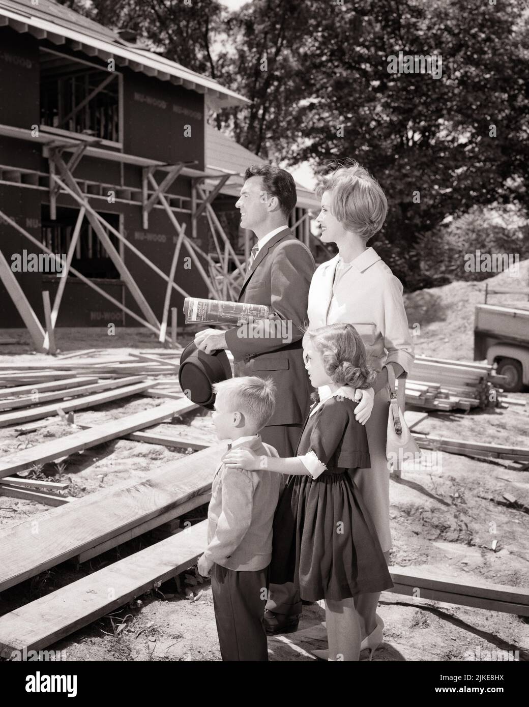 1960s FAMILY OF 4 STANDING ON CONSTRUCTION SITE OF THEIR SOON TO BE NEW HOUSE MOTHER FATHER TWO KIDS BOY GIRL - j9090 HAR001 HARS FUTURE NOSTALGIA BROTHER OLD FASHION SISTER JUVENILE STYLE DESIGN SONS FAMILIES JOY LIFESTYLE SATISFACTION ARCHITECTURE FEMALES HOUSES MARRIED BROTHERS SITE SPOUSE HUSBANDS HEALTHINESS HOME LIFE COPY SPACE HALF-LENGTH LADIES DAUGHTERS PERSONS INSPIRATION RESIDENTIAL MALES BUILDINGS SIBLINGS SISTERS B&W PARTNER GOALS SUCCESS DREAMS STRUCTURE HAPPINESS SOON ADVENTURE EXCITEMENT PROGRESS OPPORTUNITY HOMES SIBLING NUCLEAR FAMILY CONCEPTUAL RESIDENCE MID-ADULT Stock Photo