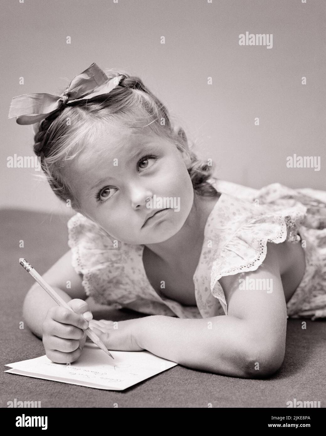 1940s THOUGHTFUL LITTLE GIRL LOOKING UP WITH SERIOUS EXPRESSION COMPOSING WRITING A LETTER - j9426 HAR001 HARS CONCERNED HAPPINESS HEAD AND SHOULDERS CHOICE UP CONNECTION CONCEPTUAL COMPOSING IMAGINATION STYLISH SINCERE SOLEMN CREATIVITY FOCUSED GROWTH INTENSE JUVENILES BLACK AND WHITE CAREFUL CAUCASIAN ETHNICITY CONSIDERING EARNEST HAR001 INTENT OLD FASHIONED Stock Photo