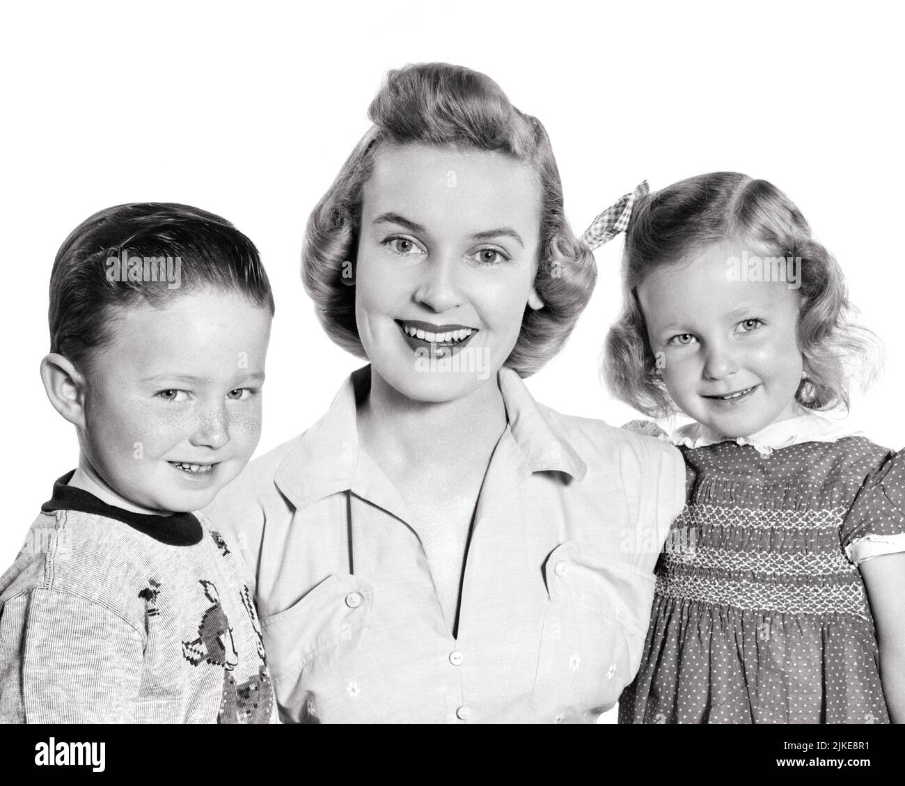 1950s PORTRAIT OF MOTHER AND TWO CHILDREN BOY AND A GIRL ALL SMILING LOOKING AT CAMERA - j995 HAR001 HARS OLD FASHION SISTER 1 JUVENILE STYLE SONS PLEASED FAMILIES JOY LIFESTYLE FEMALES BROTHERS STUDIO SHOT HOME LIFE COPY SPACE FRIENDSHIP HALF-LENGTH LADIES DAUGHTERS PERSONS MALES SIBLINGS CONFIDENCE SISTERS B&W EYE CONTACT HAPPINESS CHEERFUL AND TRIO PRIDE SIBLING SMILES CONNECTION CONCEPTUAL JOYFUL STYLISH GROWTH JUVENILES MID-ADULT MID-ADULT WOMAN MOMS TOGETHERNESS BLACK AND WHITE CAUCASIAN ETHNICITY HAR001 OLD FASHIONED Stock Photo