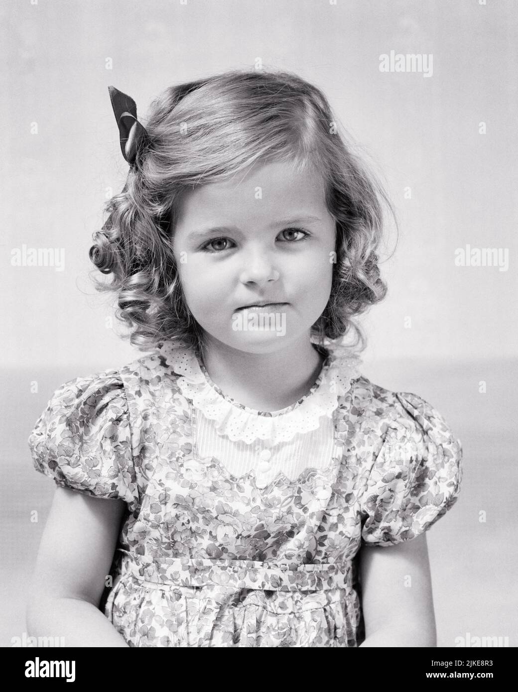 1940s SERIOUS RESOLUTE LITTLE GIRL DIRECTLY LOOKING AT CAMERA WITH A DETERMINED UNCOMPROMISING FACIAL EXPRESSION  - j9792 HAR001 HARS COURAGE KNOWLEDGE PRIDE STEADY DIRECTLY CONCEPTUAL STYLISH TRUE DETERMINED DEPENDABLE GROWTH JUVENILES RESOLUTE ATTITUDE BLACK AND WHITE CAUCASIAN ETHNICITY HAR001 OLD FASHIONED Stock Photo