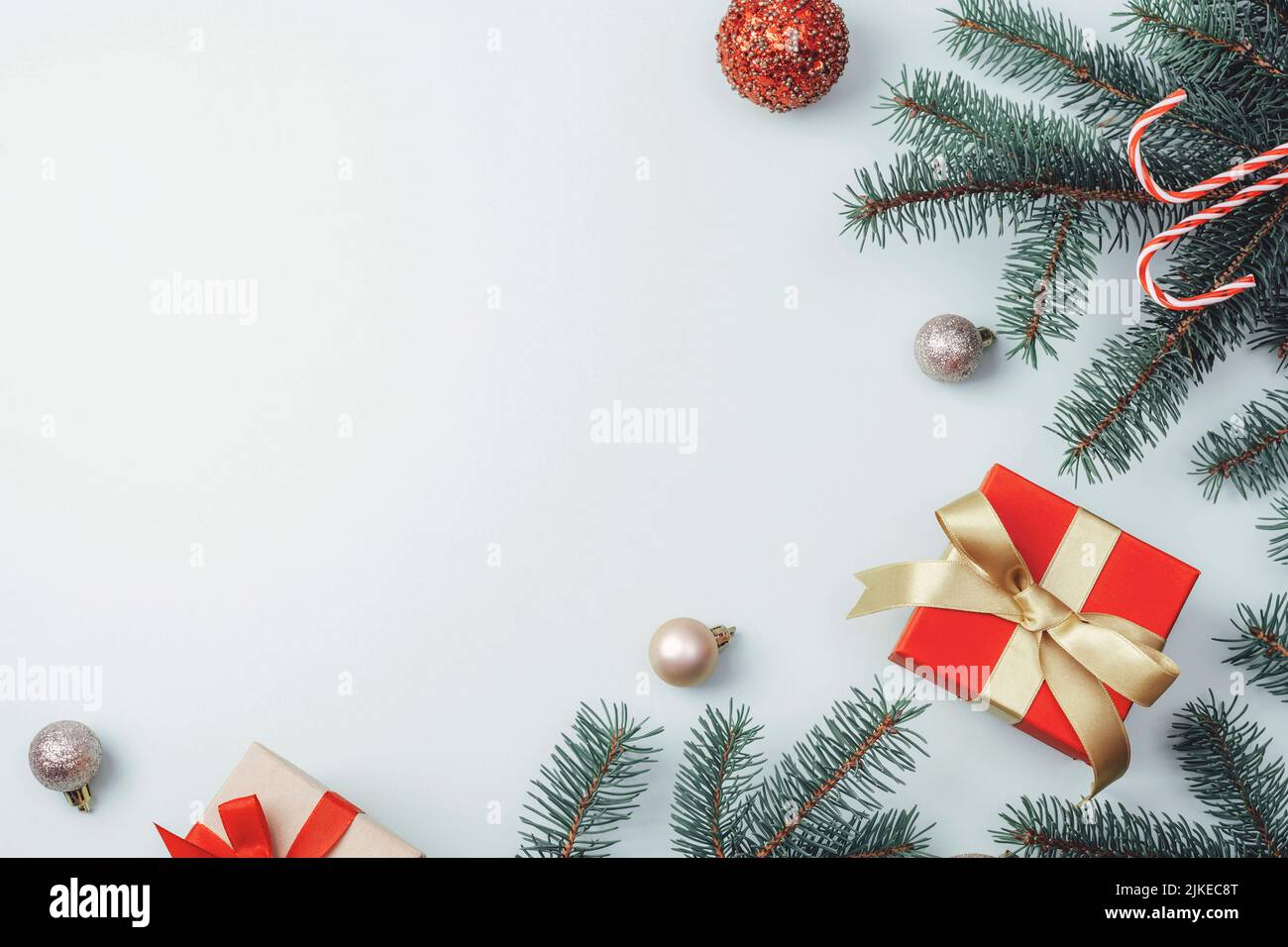 Christmas decorations, gift boxes, fir branches and candy cane on light background. Top view, flat lay, copy space. Stock Photo