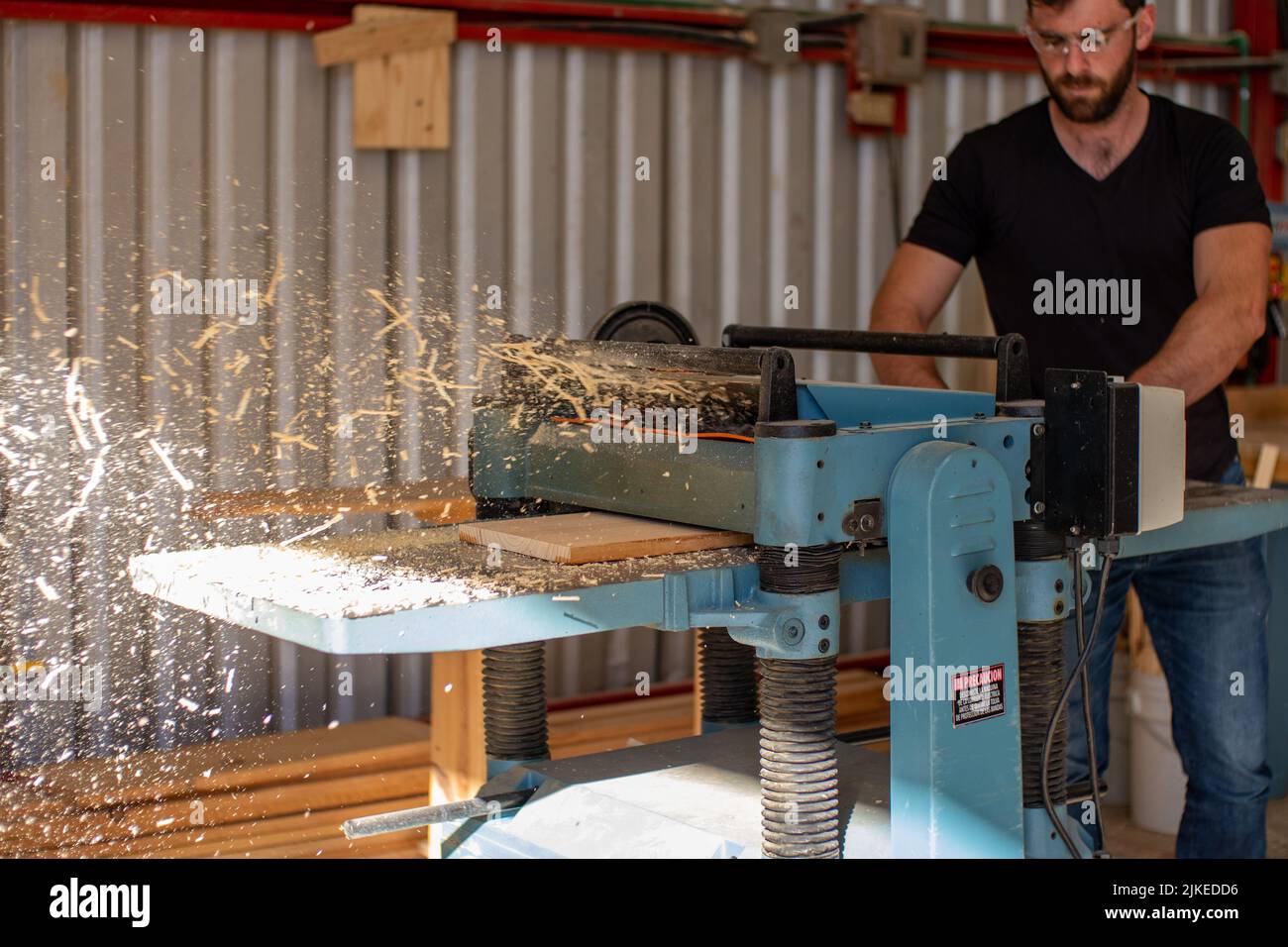 young carpenter working on an Electric Benchtop Jointer machine cutting