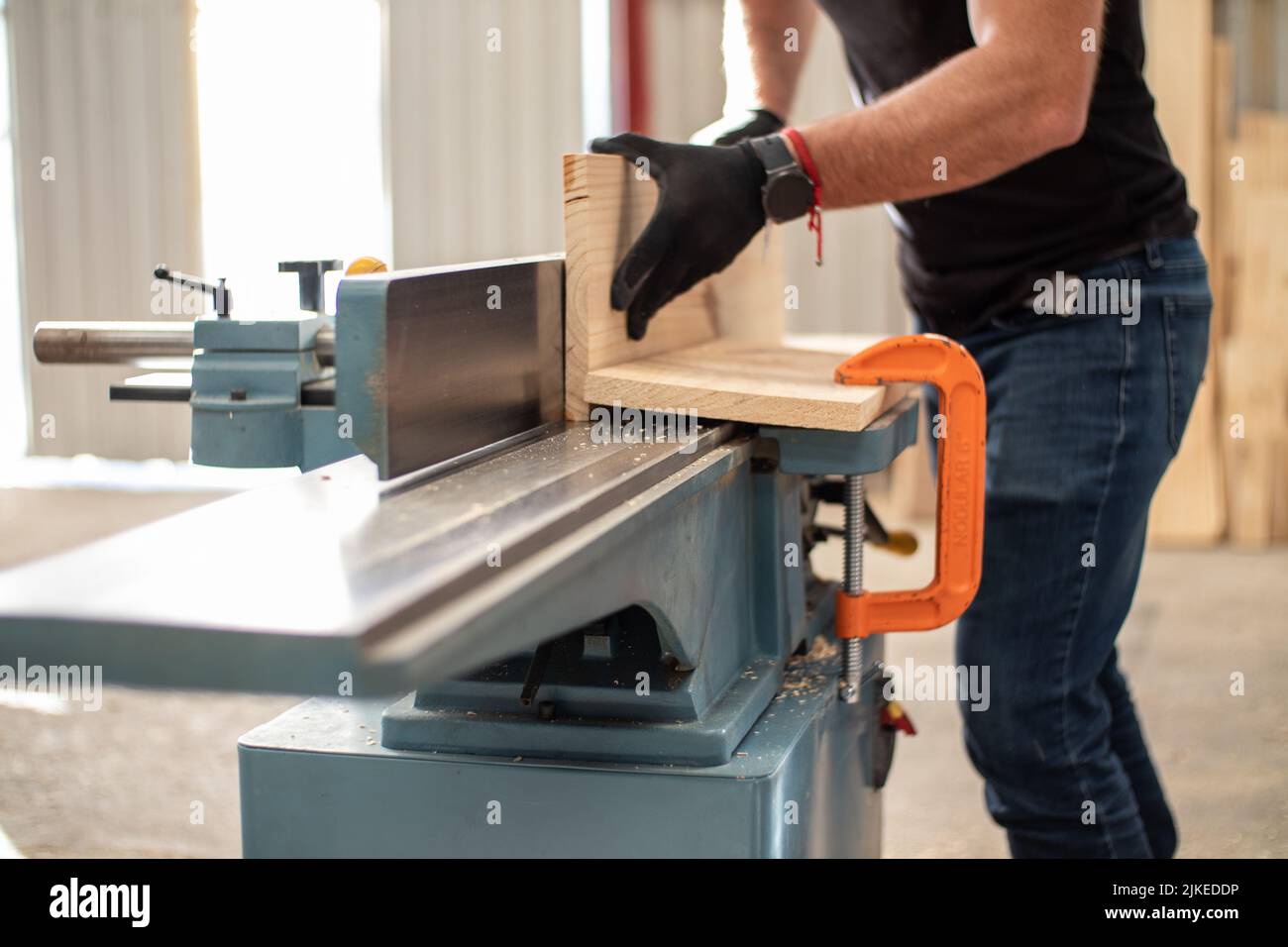 young carpenter working on an Electric Benchtop Jointer machine cutting