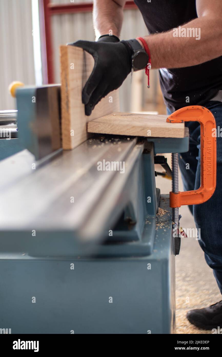 young carpenter working on an Electric Benchtop Jointer machine cutting