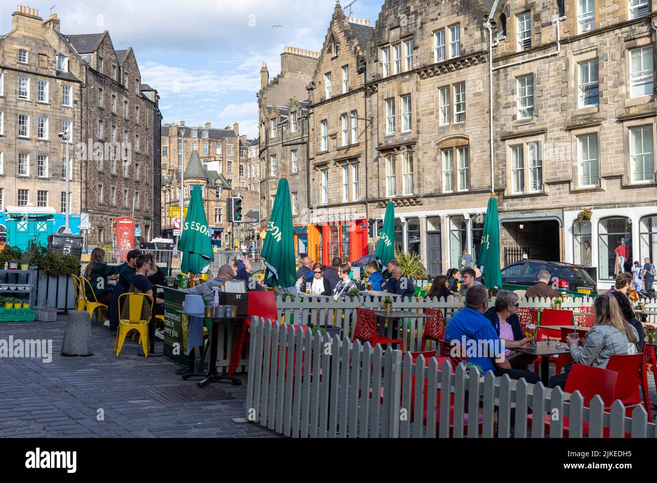 Edinburgh Grassmarket summers day 2022, people at bars and restaurants sit outside enjoying drinks and food in the sunshine,UK,2022 Stock Photo