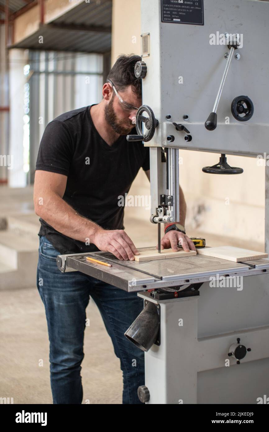 young carpenter working on an Electric Benchtop Jointer machine cutting