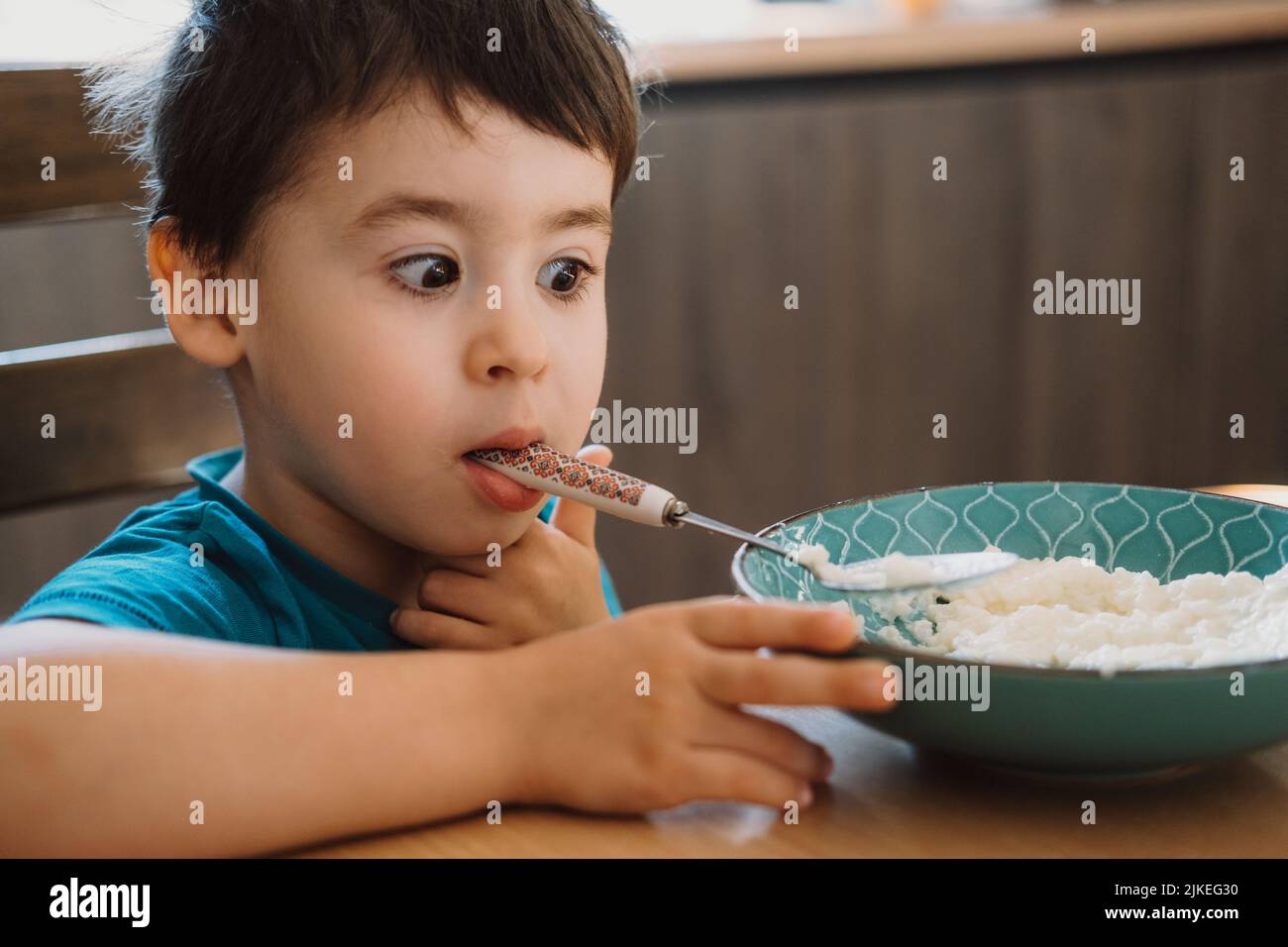 Boy who has finished eating porridge, and caress, holding the spoon in