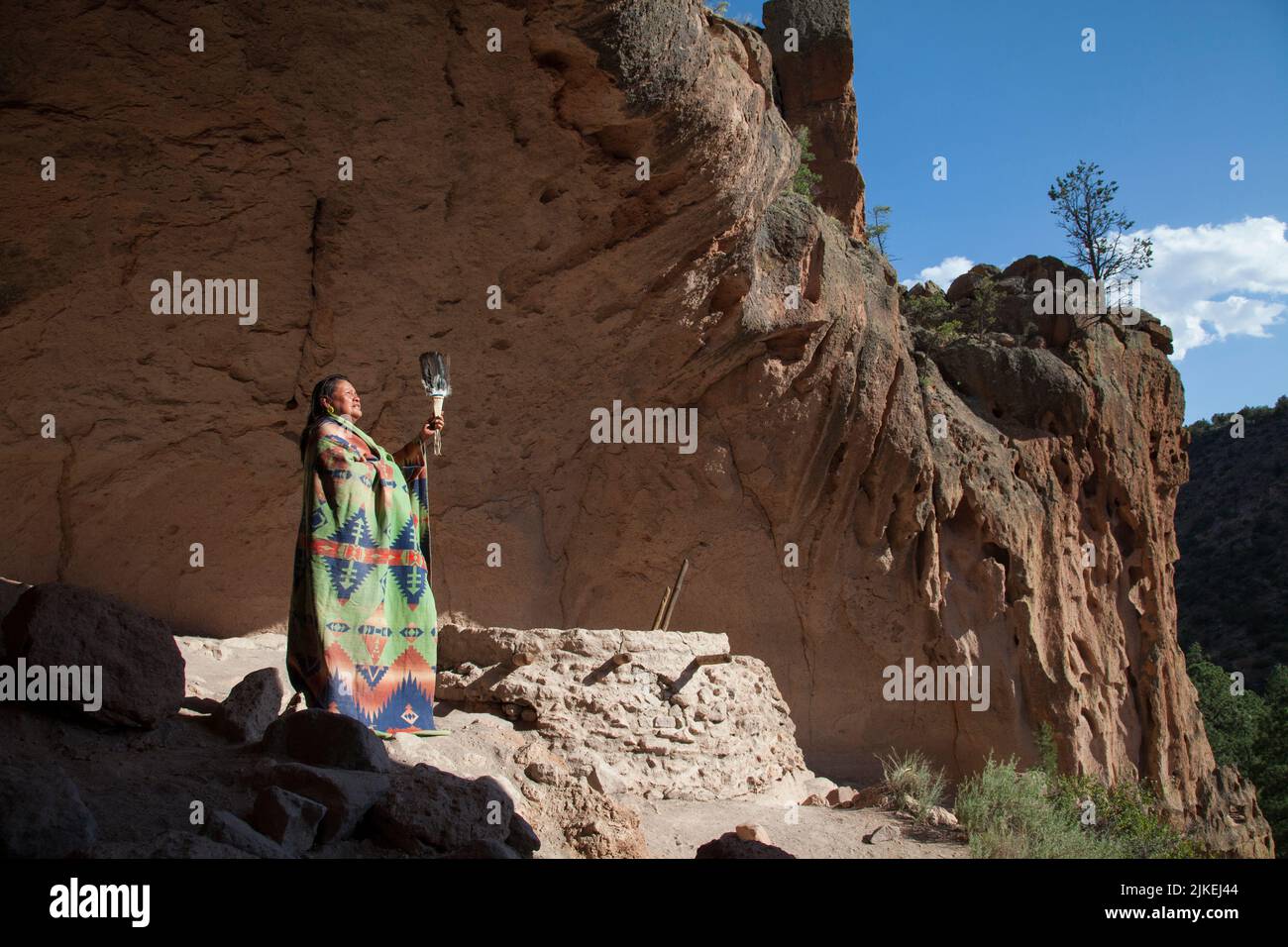 Woman wears Native American blanket and gives a blessing inside a