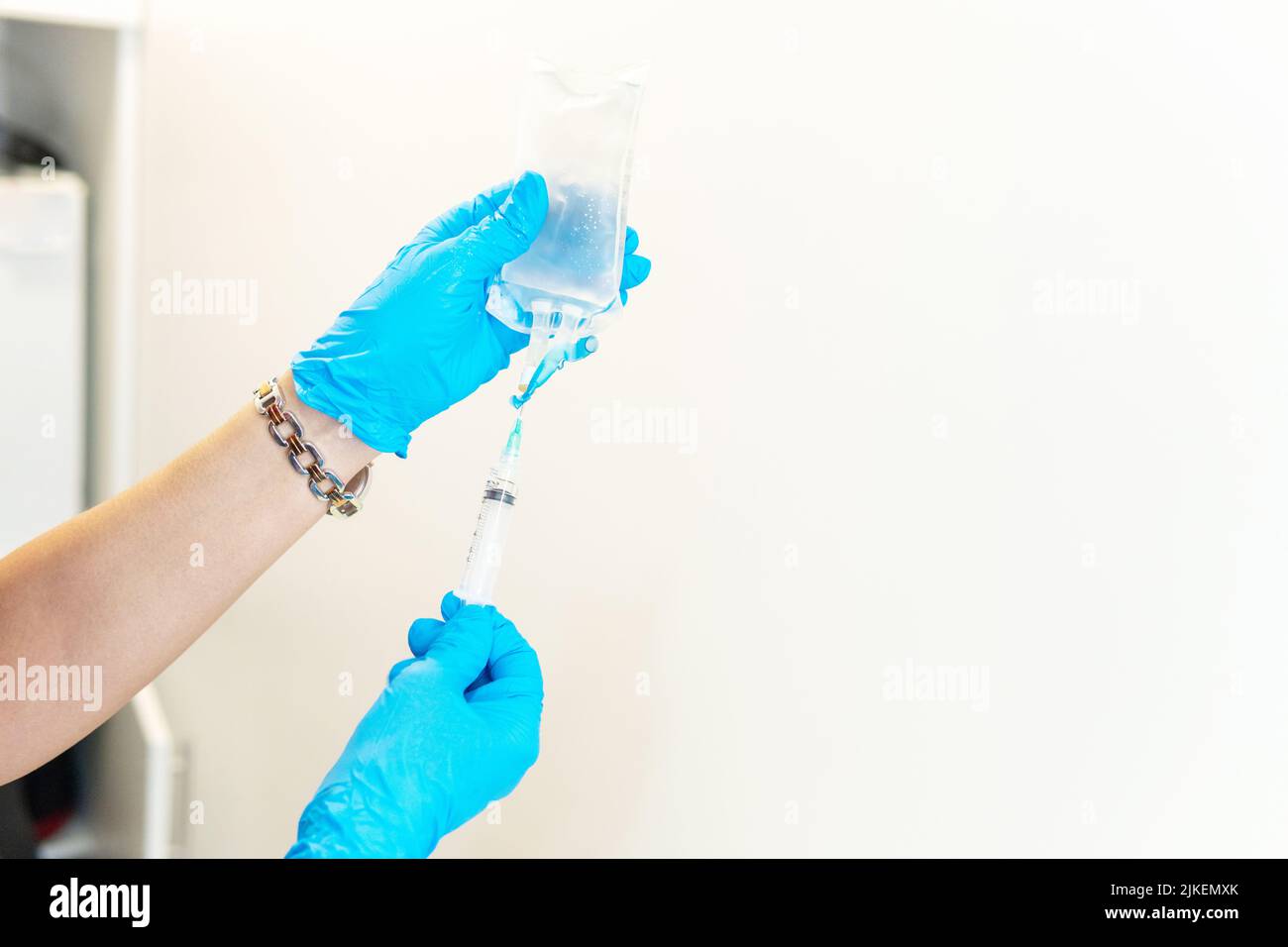 Close-up of hands with surgical gloves preparing medicine in a syringe. Preparing hyaluronic acid Stock Photo