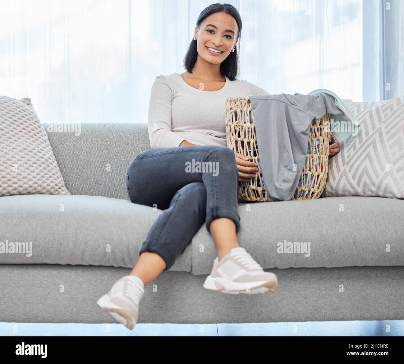 All done with the chores. a young woman sitting on the couch at home Stock Photo Alamy