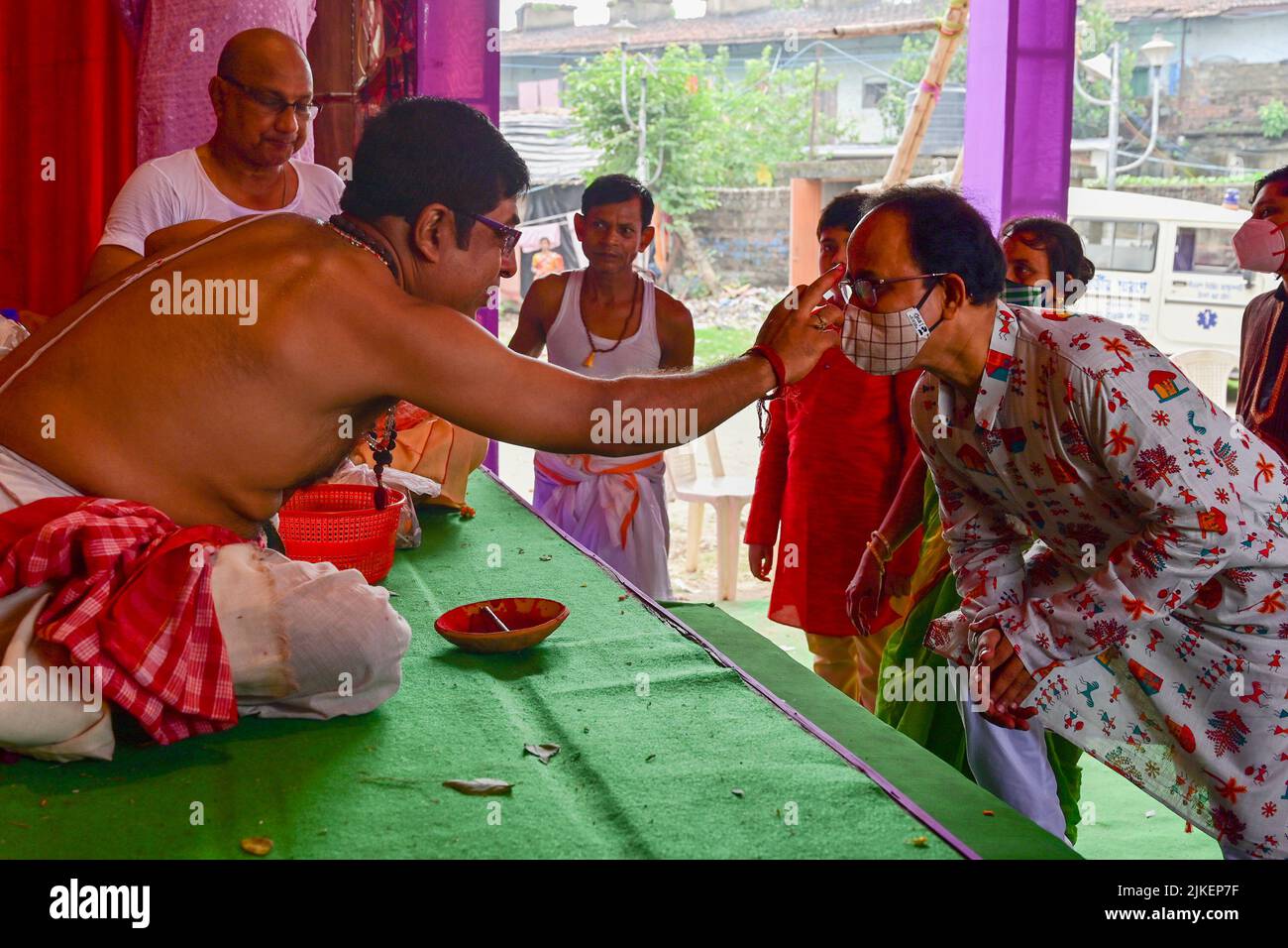 Howrah, West Bengal, India - 14th October 2021 : Hindu Purohit putting holy tilak on foreheads of devotees during pushpanjali puja to Goddess Durga. Stock Photo