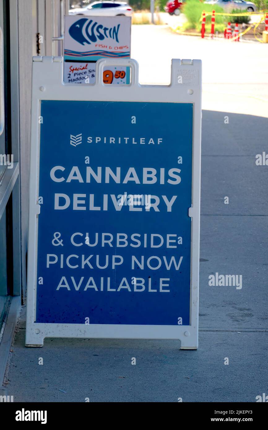 A sandwich board set up outside SpirtLeaf Cannabis shop advertising delivery and curb-side pickup in Maple Ridge, B. C., Canada. Stock Photo