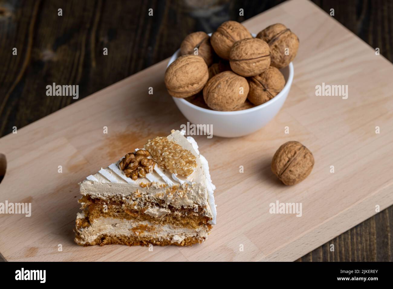 a piece of cake with buttercream and walnuts, a sweet and delicious