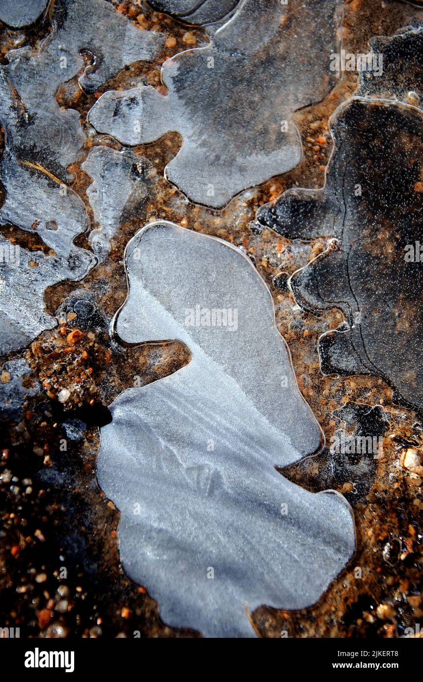 Interesting shapes and patterns of melting ice on the ground in the Colorado mountains. Stock Photo