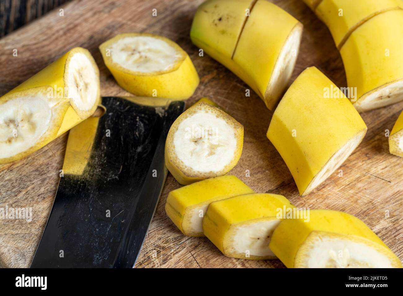 cut into many pieces of banana in the peel , not peeled ripe yellow banana cut into pieces on a