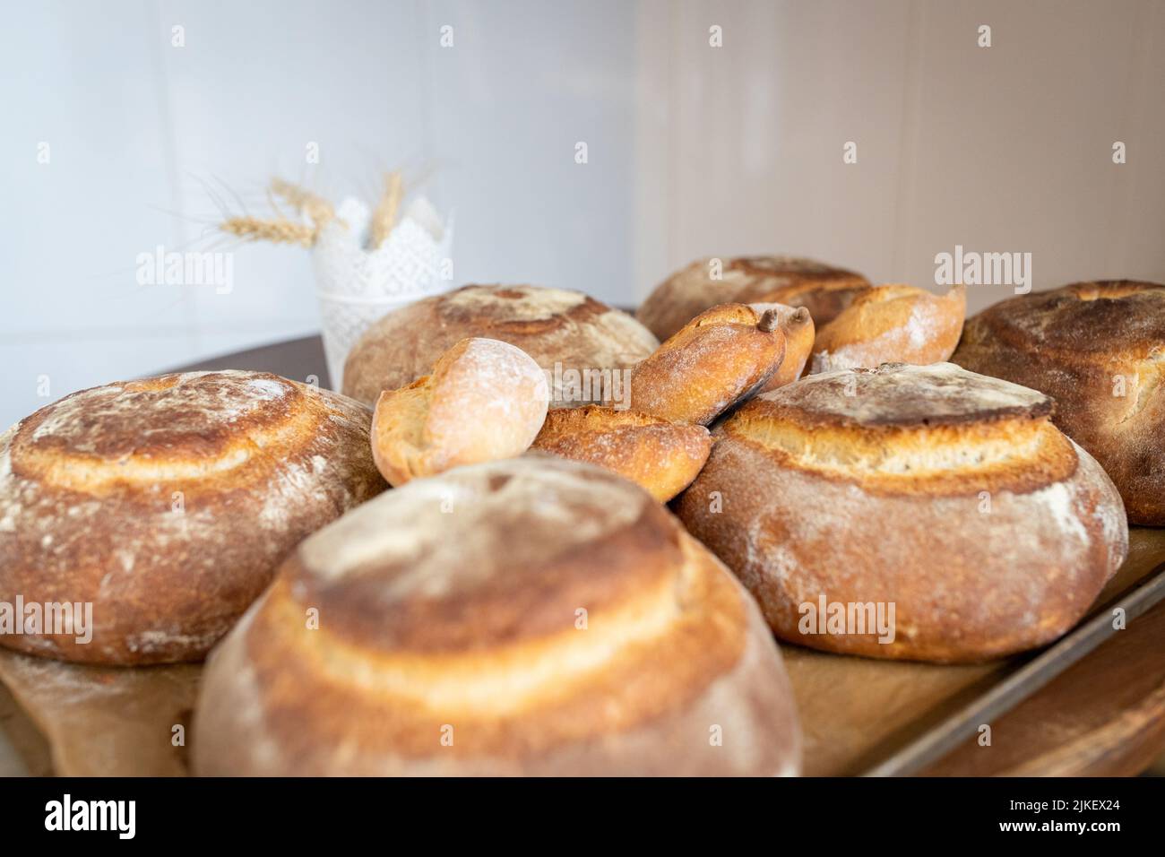 Artisan bread only from the oven on the table in a small home bakery. Front view. Stock Photo