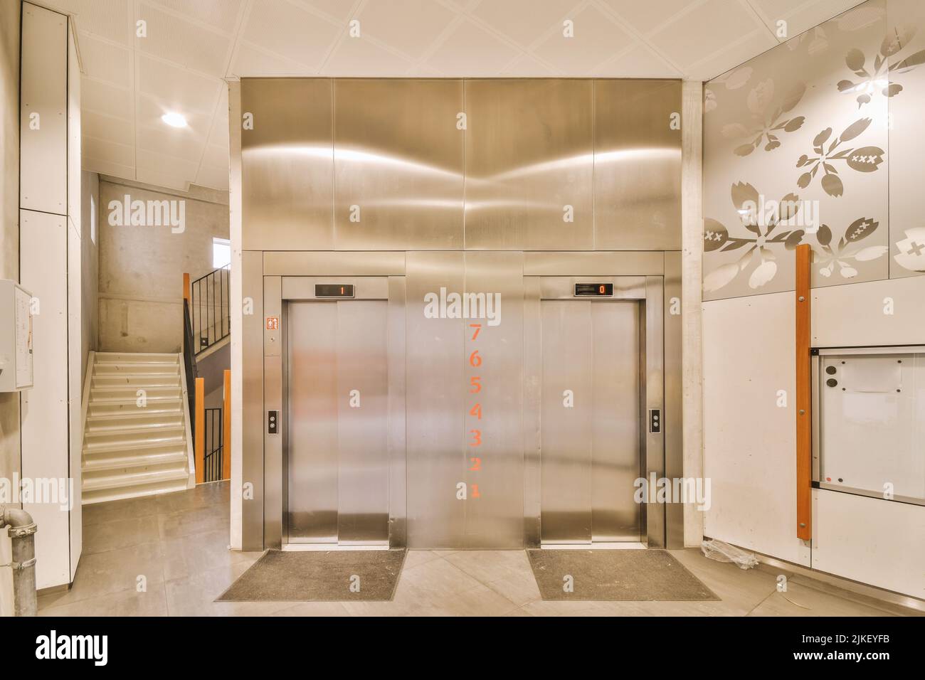 Shiny elevator in illuminated hall of contemporary apartment building with tiled floor Stock Photo