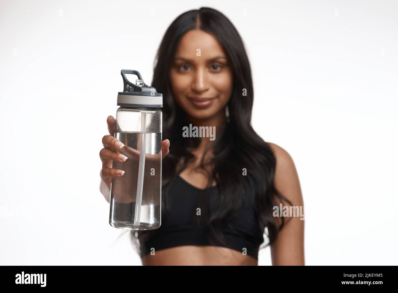 Water makes your muscles stronger. Studio portrait of a sporty young woman holding a water