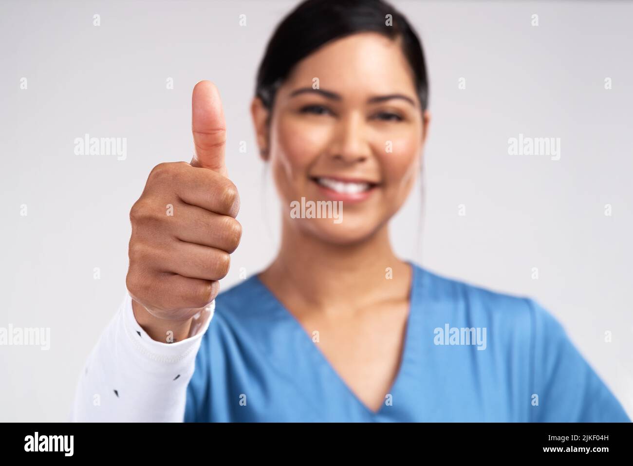 Im a force of God. Portrait of a young doctor showing a thumbs up sign against a white background. Stock Photo