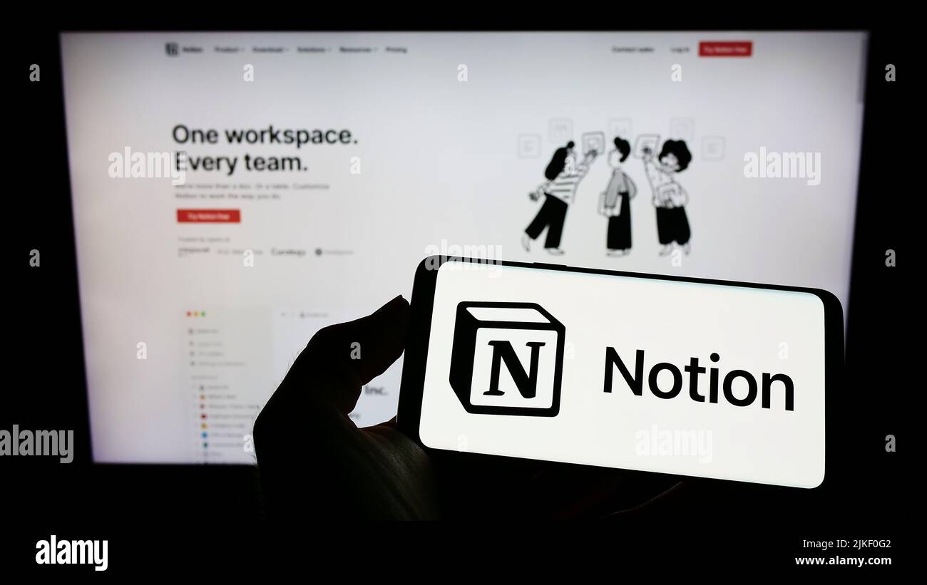 Person holding smartphone with logo of US software company Notion Labs Inc. on screen in front of website. Focus on phone display. Stock Photo