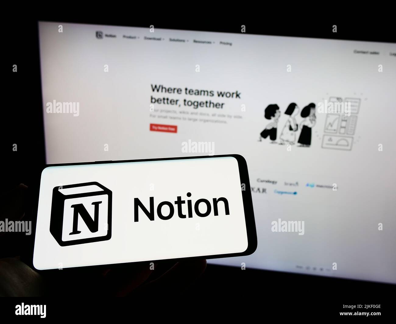 Person holding cellphone with logo of US software company Notion Labs Inc. on screen in front of business webpage. Focus on phone display. Stock Photo