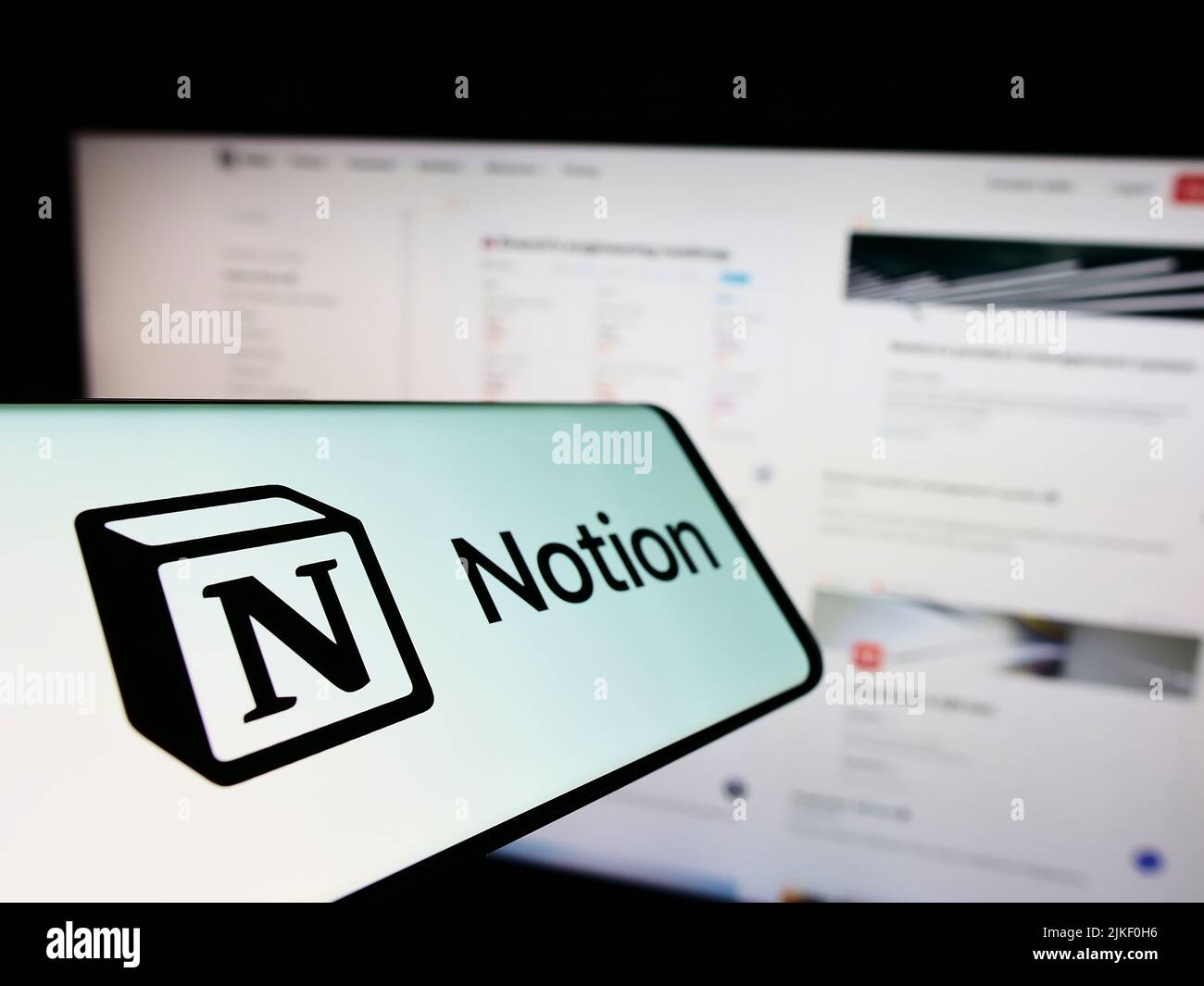 Smartphone with logo of American software company Notion Labs Inc. on screen in front of business website. Focus on center-left of phone display. Stock Photo