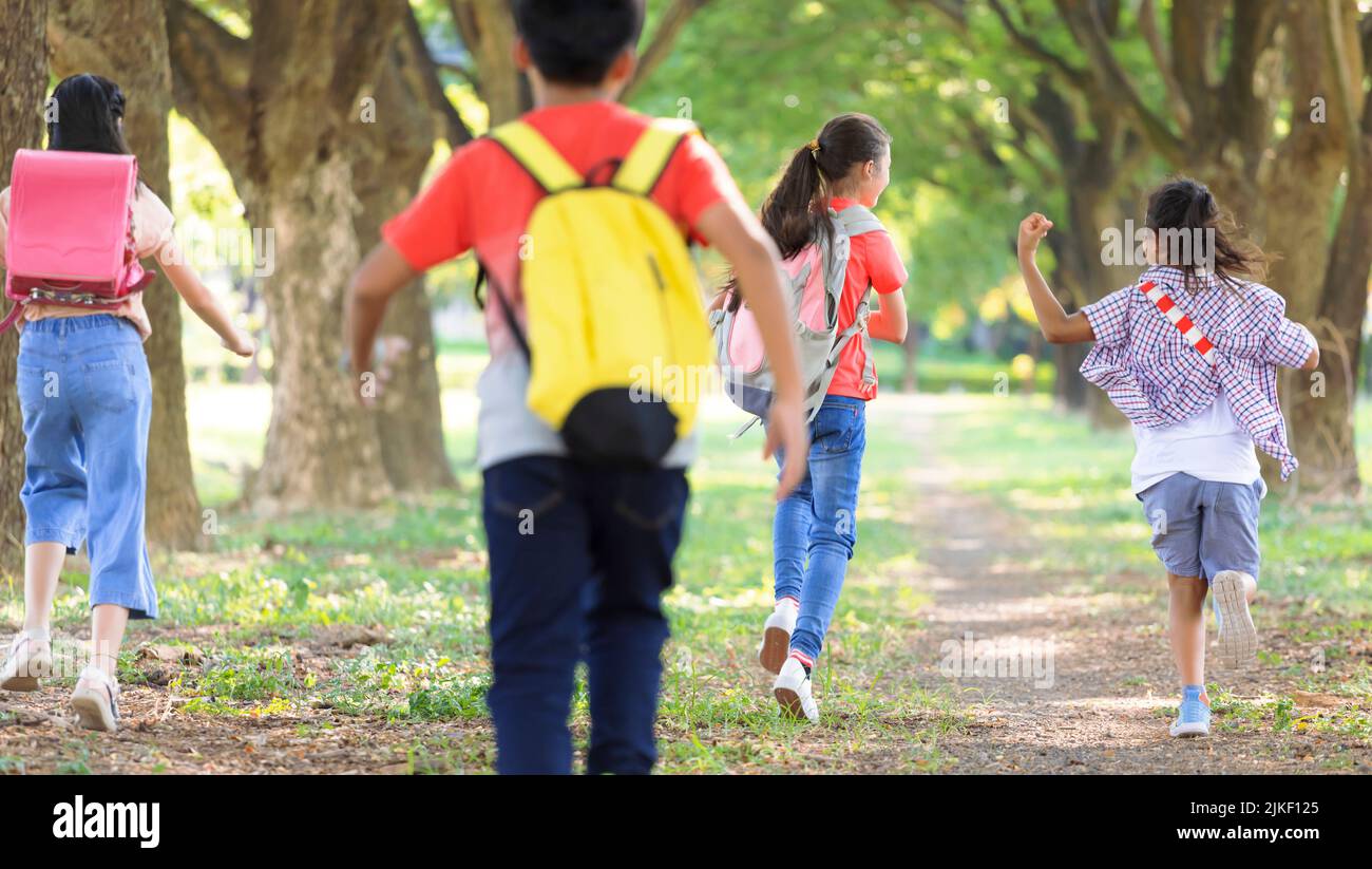 Rear view elementary school kids running at school. back to school Stock Photo