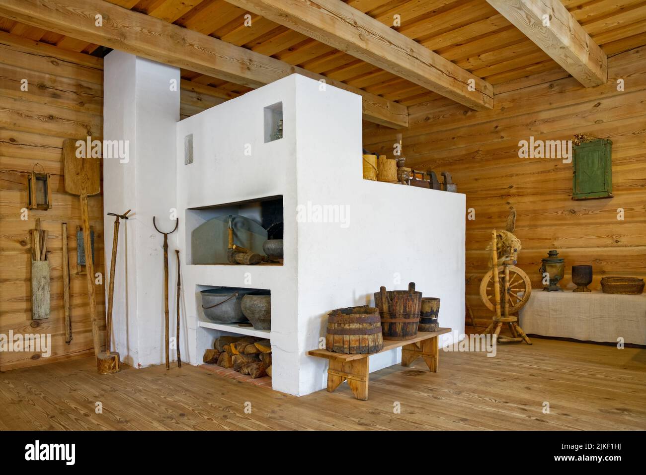 The interior of an old Russian house with a traditional oven. Russian stove and furniture. Stock Photo