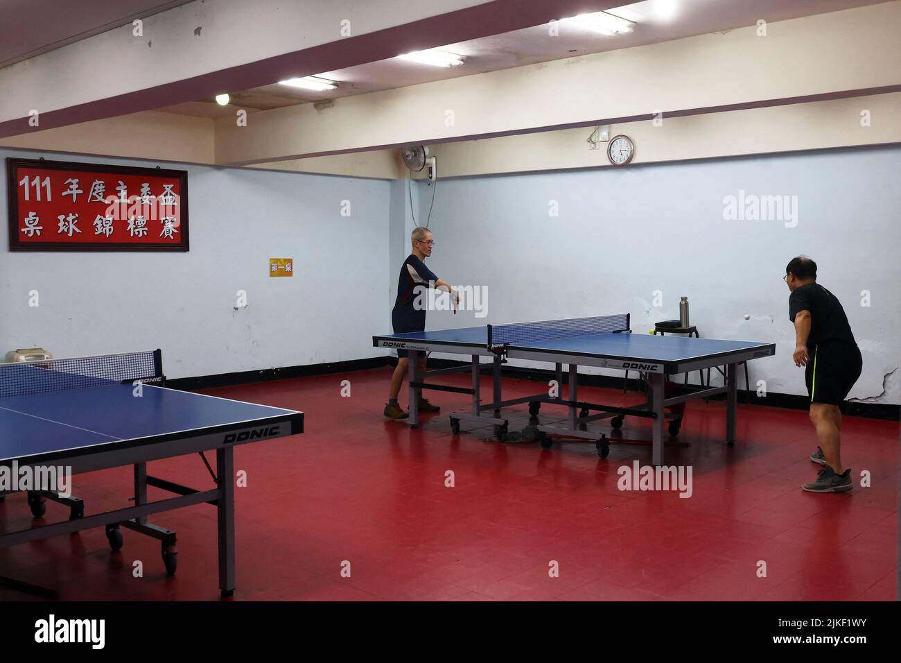 Men play ping pong at a table tennis club in an underground space that will  be used as an air-raid shelter in the event of an attack, beneath a  residential building in