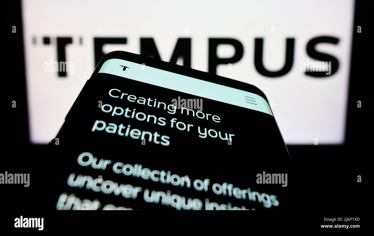 Mobile phone with website of US health care company Tempus Labs Inc. on screen in front of business logo. Focus on top-left of phone display. Stock Photo
