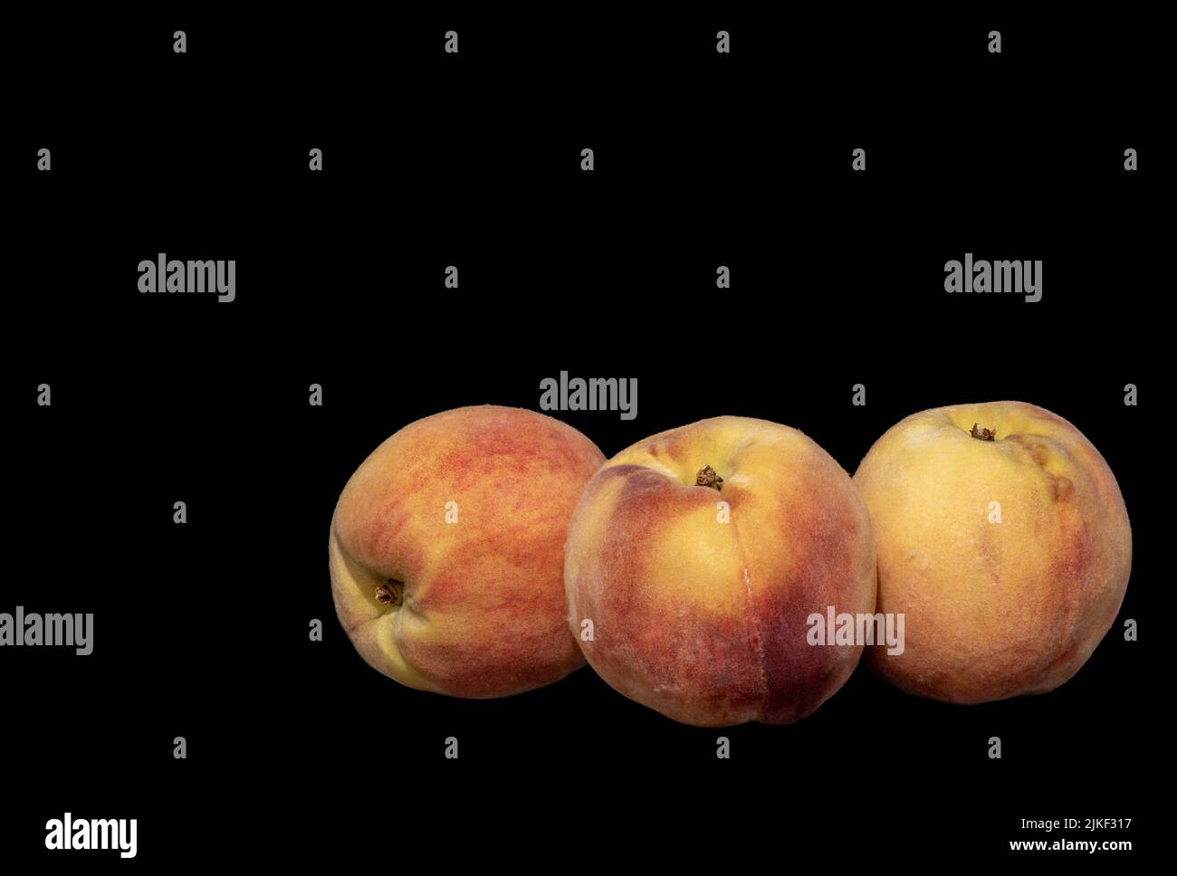 Image of three ripe peaches on black background Stock Photo