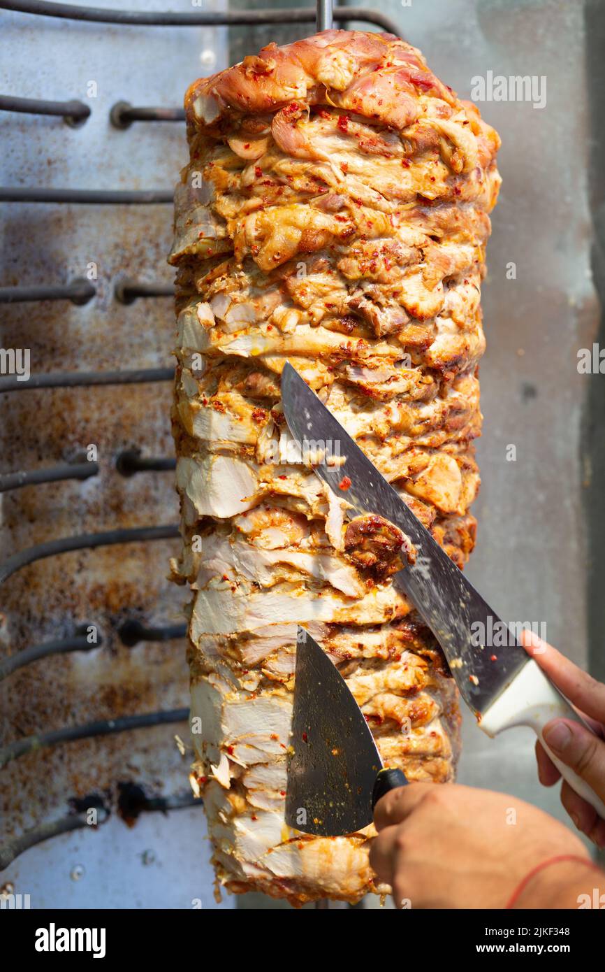 Chef cutting with doner knife Traditional Turkish Doner Kebab meat