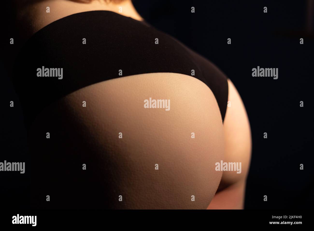 Photo of woman hips wearing black lingerie in shadow Stock Photo
