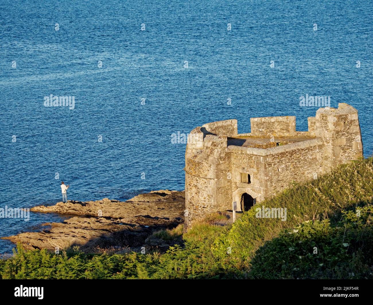 Man Fishing, Rocks and Castle, Little Dennis Fort,  Pendennis Point, Falmouth, Cornwall, England, UK, GB. Stock Photo