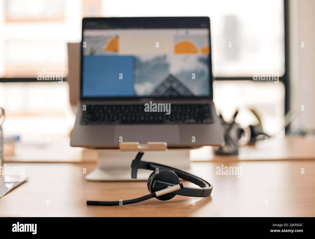 All set up and ready to help. Still life shot of a wireless headset on a desk in a call center. Stock Photo