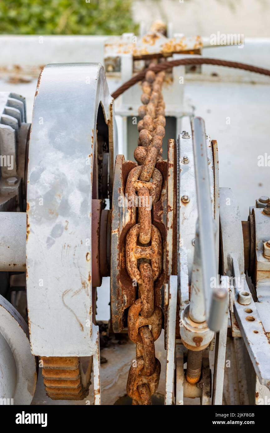 Old rustic iron chain with anchor machine close up with selective focus Stock Photo