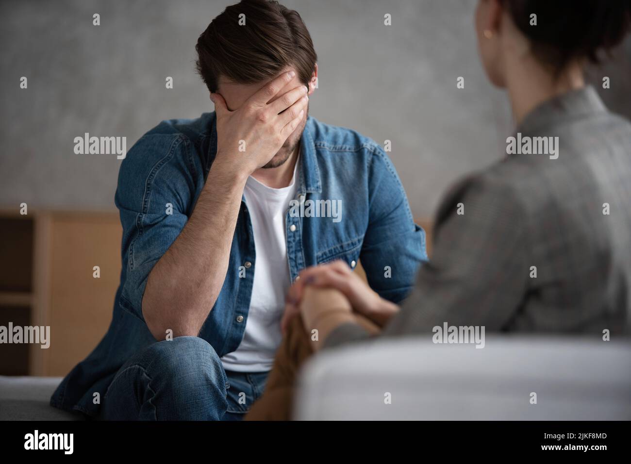 Psychologist talking with patient on therapy session. Depressed man