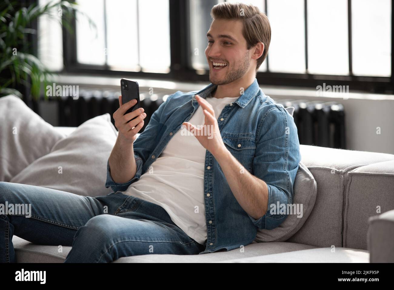 Online video call. Positive man waving hand to webcam, having pleasant talk  with friends or family Stock Photo - Alamy