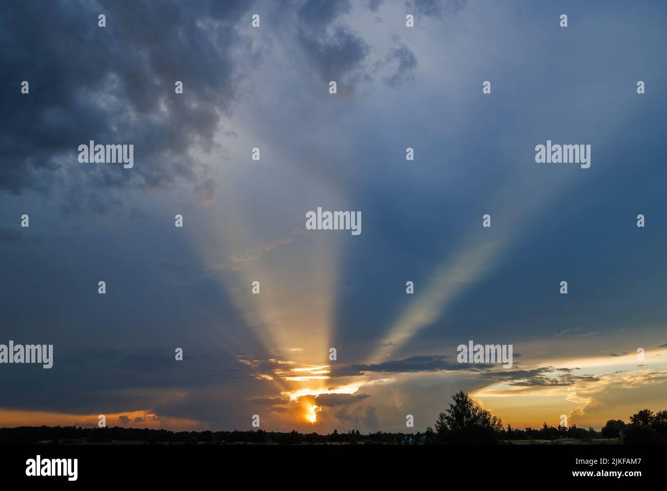 cloudy sunset sky with yellow sun rays without horizon Stock Photo