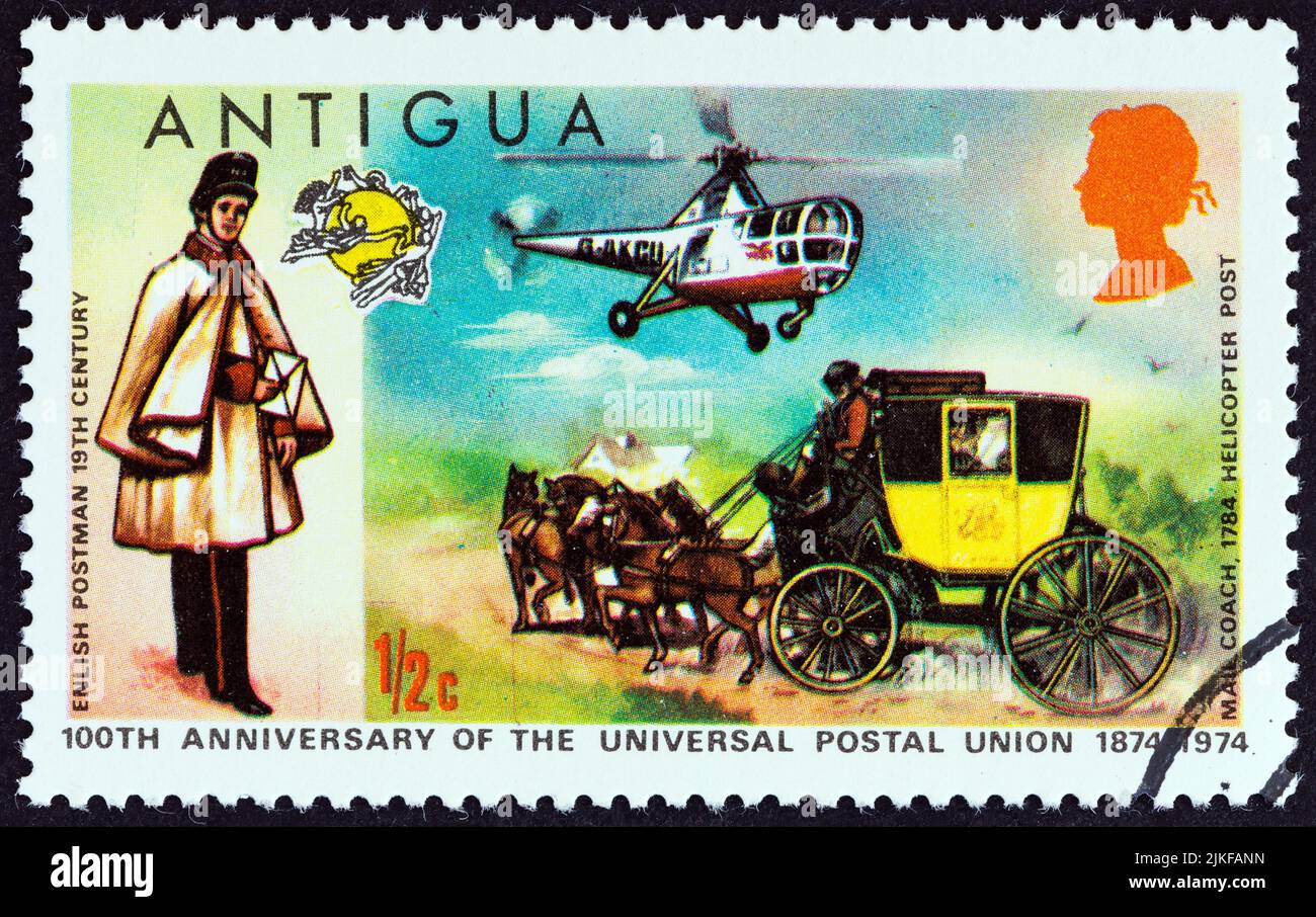 ANTIGUA - CIRCA 1974: A stamp printed in Antigua issued for the Centenary of U.P.U. shows English Postman, Mailcoach and Westland Dragonfly Helicopter Stock Photo