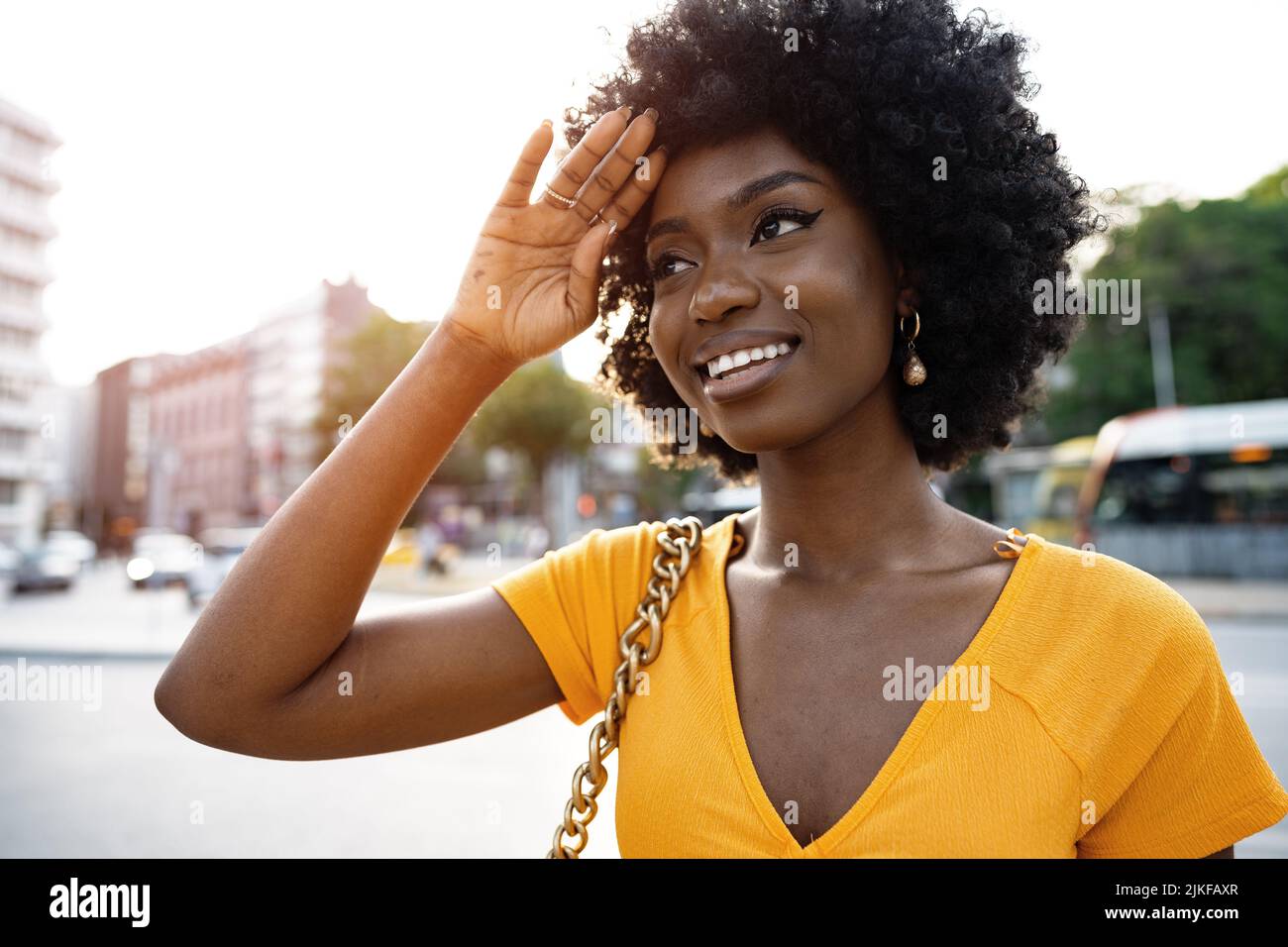 Portrait of a young african american woman smiling standing at the city ...